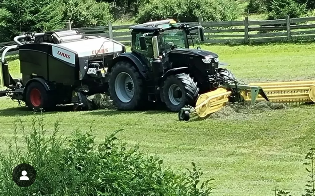 Traktor bei Mäharbeiten auf dem Feld - landwirtschaftliche Dienstleistung